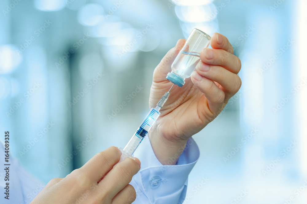 Doctor gaining medicine into the syringe . Doctor gaining medicine into the syringe .