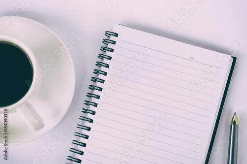 Top view of coffee, blank notepad and pen retro styled