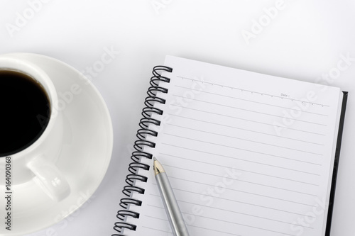 Top view of blank notepad with black coffee and pen on white background