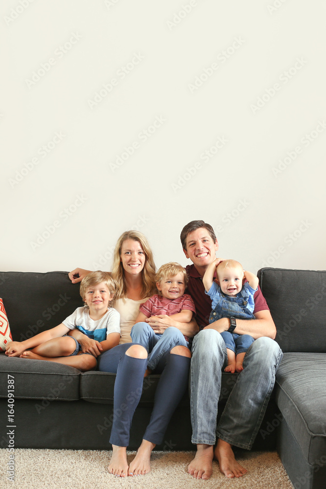 Young family with three boys lifestyle at home on the couch playing together Young family with three boys lifestyle at home on the couch playing together