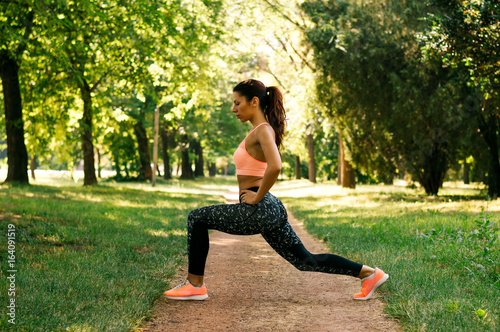 Pretty woman doing exercises in the park. photo