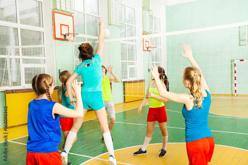 Girl serving jump float during volleyball match