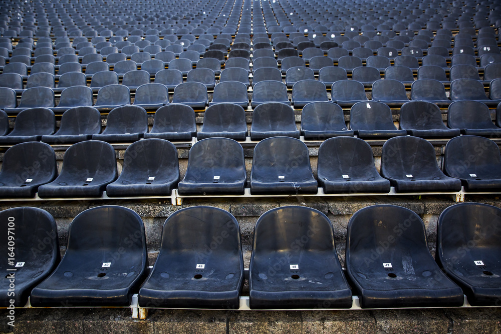 Naklejka premium Empty tribune with black seat on soccer sdadion