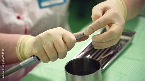 Dentist preparing to work. Assembly of dental drill. Installation of sterile borer. Profetional dentist at work. photo