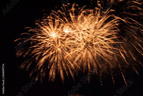 Multiple yellow fireworks exploding
