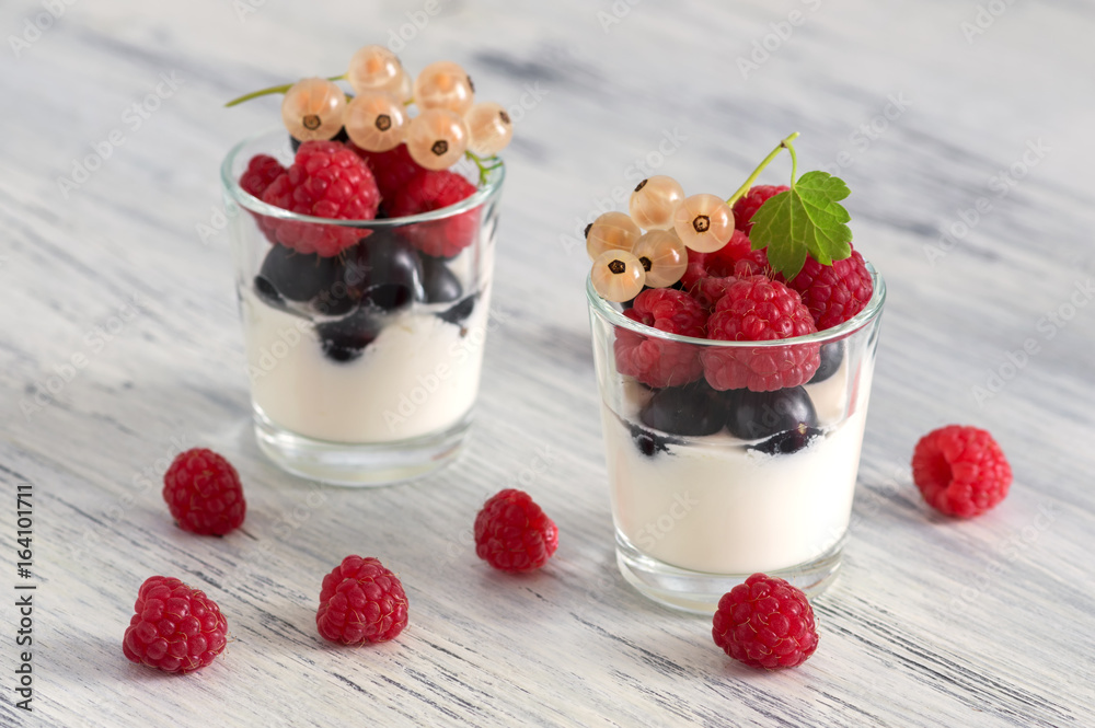 Yogurt with raspberries and currants in a small glass. Black currant, white currant Yogurt with raspberries and currants in a small glass. Black currant, white currant
