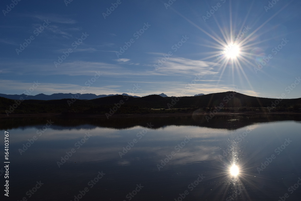Sun over mountains and lake in South Africa