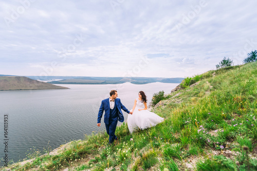 Beautiful wedding couple on a romantic walk at a marvelous bay. © Ivan