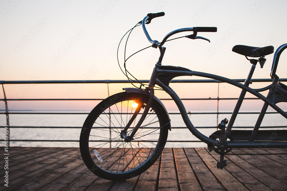 Picture of a tandem bicycle outdoor on sunset or sunrise