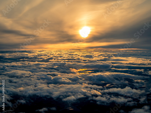 Closeup large clouds in sunset sky from the view of an airplane window.