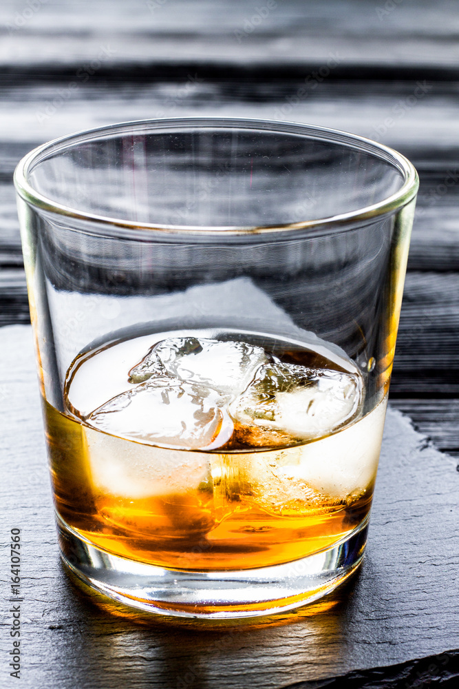 glass of whiskey on dark wooden background glass of whiskey on dark wooden background