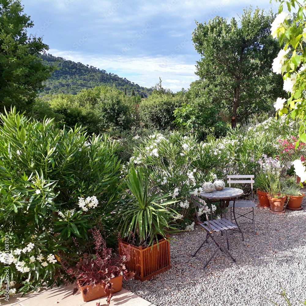 Fototapeta premium Cosy french garden in Provence with pots and garden furniture