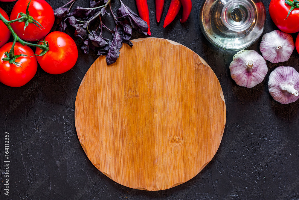 Mockup for menu. Cutting board and vegetables on black background top view Mockup for menu. Cutting board and vegetables on black background top view