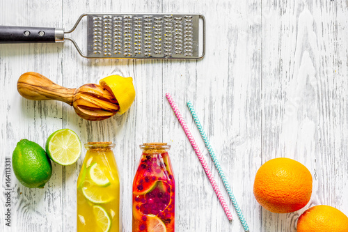 Bottle with fresh lemonade and fruits on wooden background top view copyspace