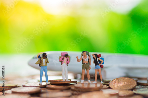 Miniature people : Backpacker travel to destinations by plane on the stack coin . Using as travel business concept