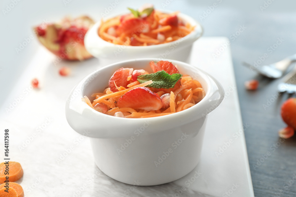 Cute white bowl with yummy carrot strawberry salad on marble board Cute white bowl with yummy carrot strawberry salad on marble board