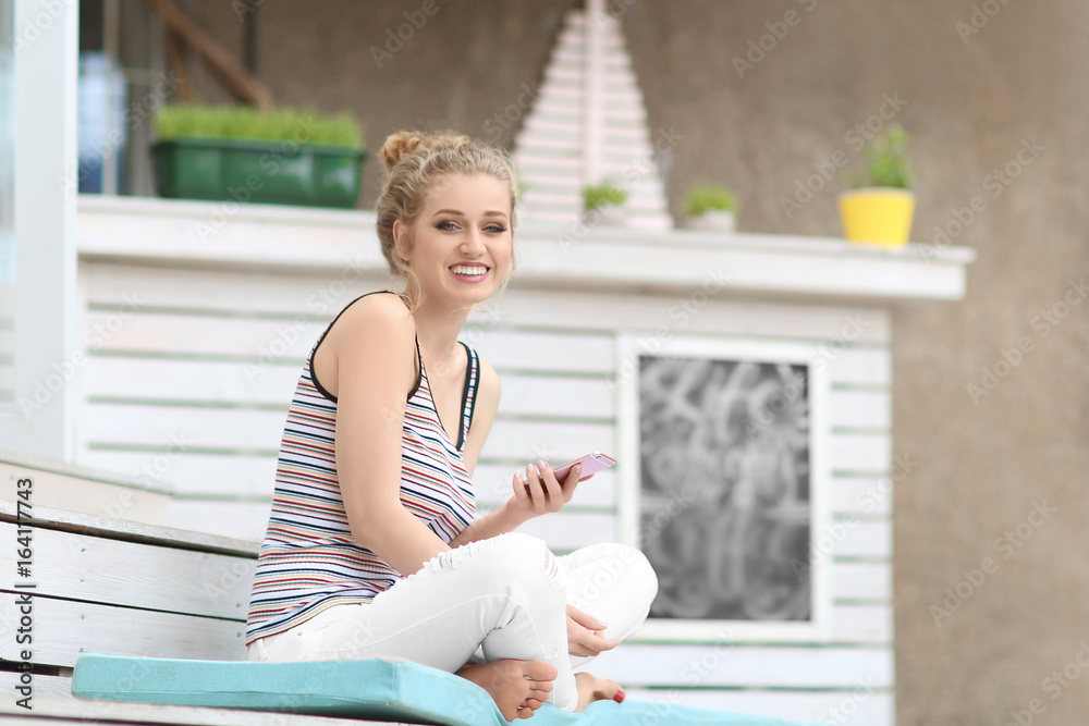 Beautiful young woman with mobile phone sitting on stairs outdoors Beautiful young woman with mobile phone sitting on stairs outdoors
