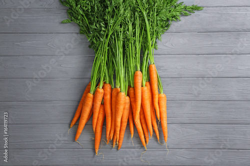 Fresh organic carrots on wooden background