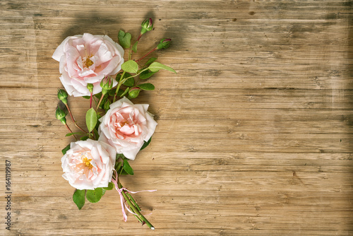 bouquet of pink roses on a wooden table, top view with copy space