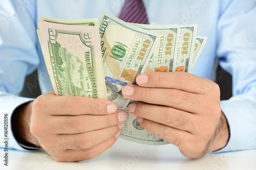 Businessman counting money,US dollar (USD) bills, on the table