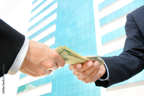 Bild auf Leinwand Hands of businessmen passing money, US dollar bills