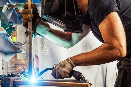 Fotografi man welds a metal welding machine
