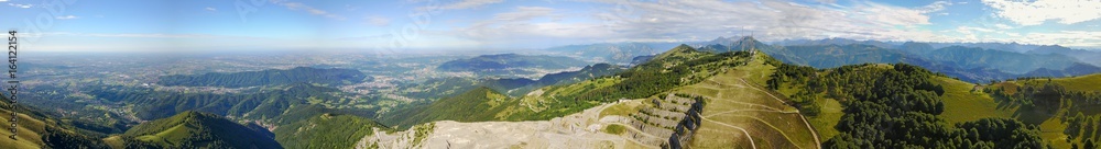 Great landscape on the Padana plain in summer time and the concrete quarry. Panorama from Linzone Mountain, Bergamo, Italy. 