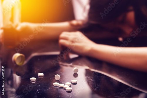 overdose , drug addiction problem concept : Several pill spilled on table Near bottle of alcohol. photo