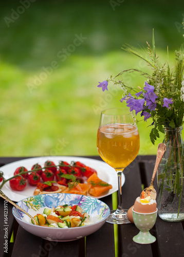 Fresh Summer Outdoor Romantic Breakfast in Park with Eggs, Berries, Flowers