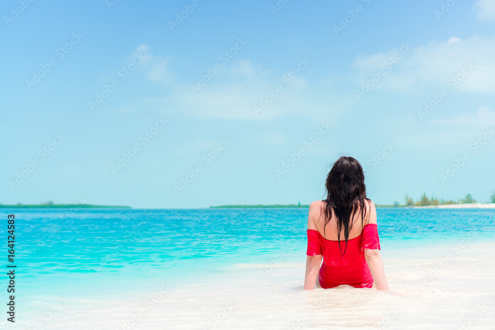 Young beautiful girl on the beach at shallow tropical water Young beautiful girl on the beach at shallow tropical water