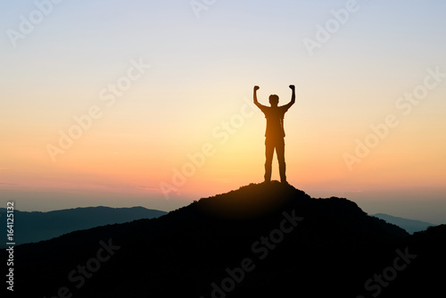 man standing on top of mountain at sunset background  silhouette