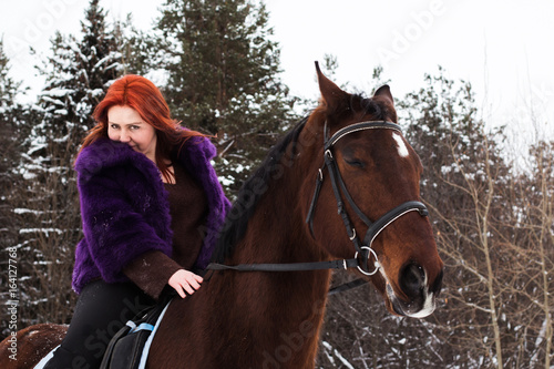 Woman with red hair and big horse outdoor in winter © keleny