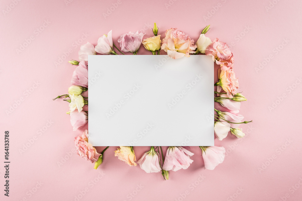 Top view of blank greeting card and tender eustoma flowers isolated on pink Top view of blank greeting card and tender eustoma flowers isolated on pink