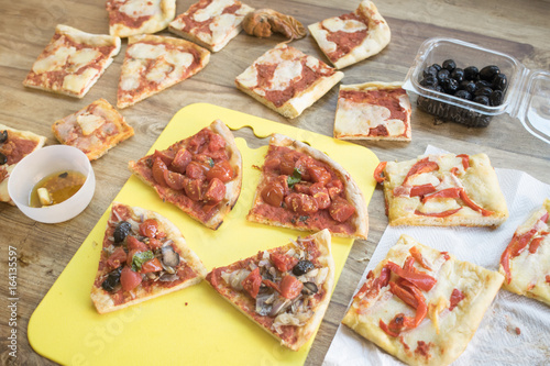 variety of pieces of pizza on a wooden table