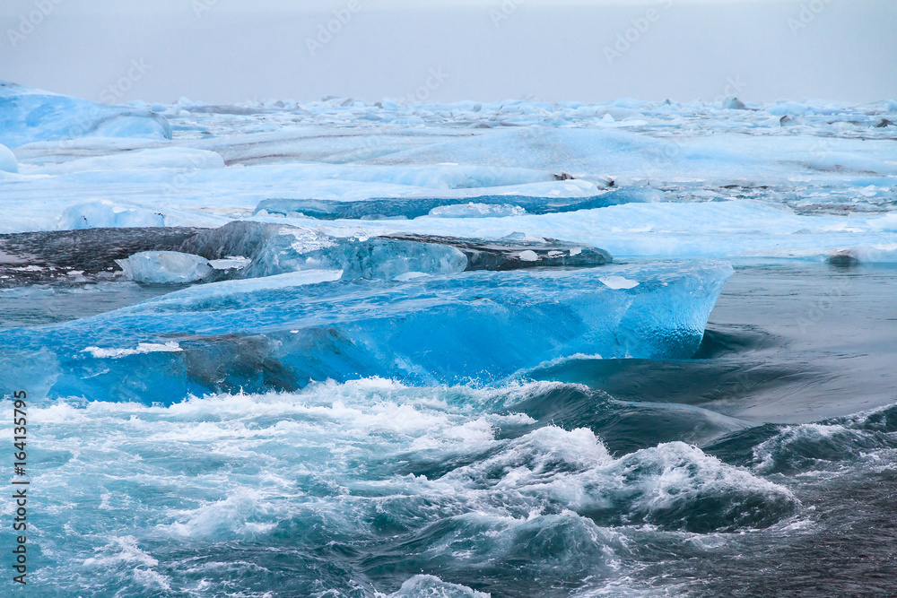 Beautiful view of the flowing water in the river leading to the sea from the Jokulsarlon lake with icebergs in winter Beautiful view of the flowing water in the river leading to the sea from the Jokulsarlon lake with icebergs in winter