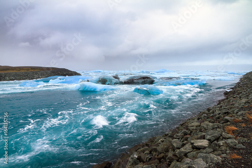 Beautiful view of the flowing water in the river leading to the sea from the Jokulsarlon lake with icebergs in winter