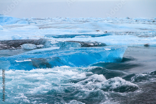Beautiful view of the flowing water in the river leading to the sea from the Jokulsarlon lake with icebergs in winter