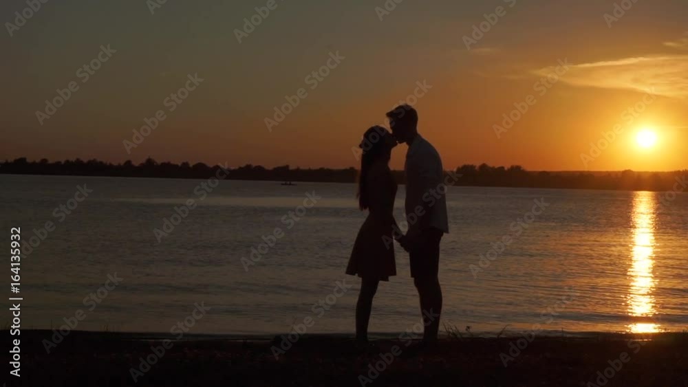 Loving senior couple enjoying a romantic sunset evening dancing together on the beach filmed Loving senior couple enjoying a romantic sunset evening dancing together on the beach filmed