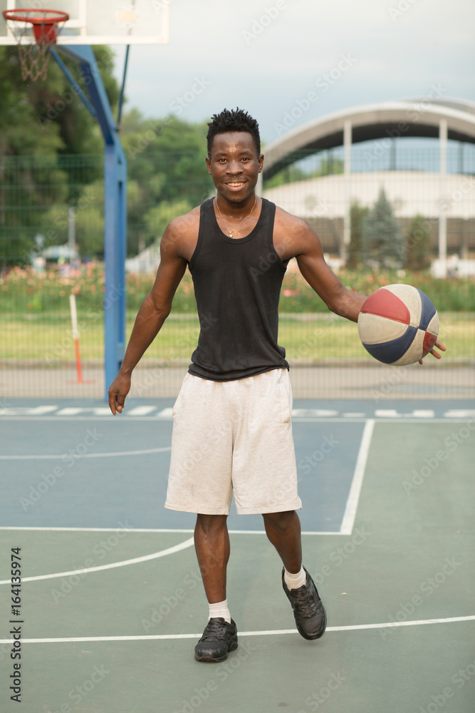 African american man on basketball court dribbling with ball. Real and authentic activity.