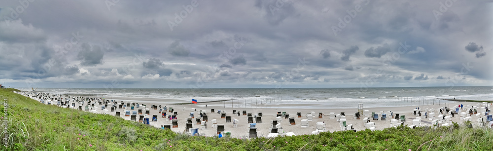 Panorama eines Nordseestrandes auf Norderney mit Strandkörben bei Sturm Panorama eines Nordseestrandes auf Norderney mit Strandkörben bei Sturm