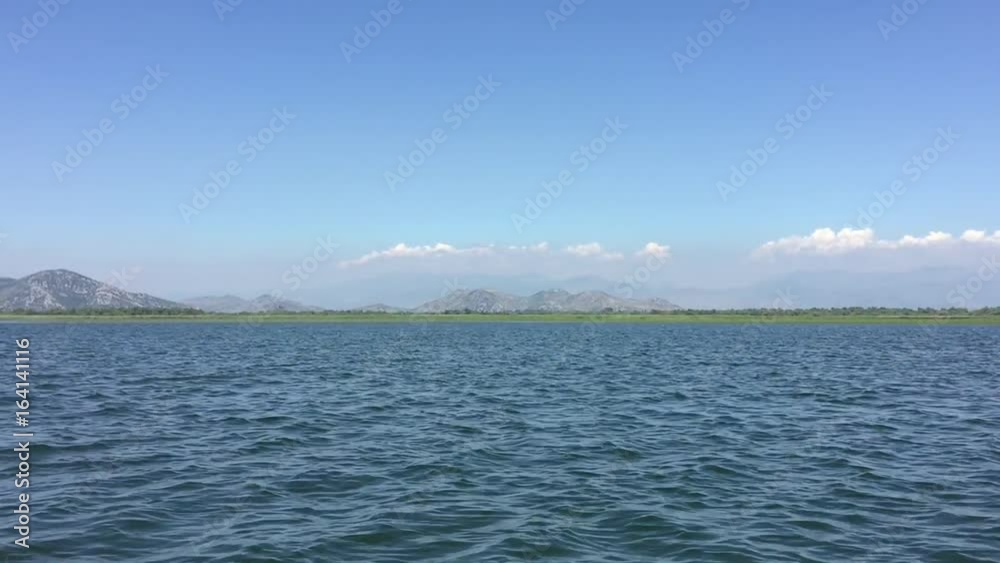 Walk by beautiful lake on boat. Summer day, Blue water. Huge Lake Skadar Montenegro. Largest lake in Montenegro. Trip by lake Skadar beautifull flora and fauna. Great nature place. Walk by beautiful lake on boat. Summer day, Blue water. Huge Lake Skadar Montenegro. Largest lake in Montenegro. Trip by lake Skadar beautifull flora and fauna. Great nature place.