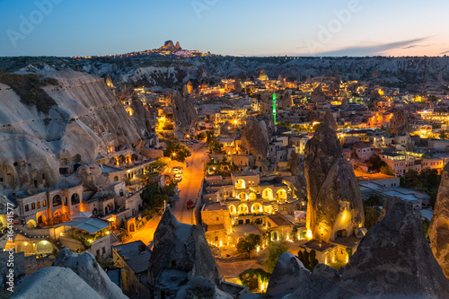 Ancient town and a castle of Uchisar dug from a mountains after twilight. photo