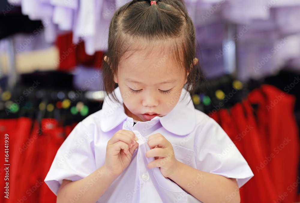 Cute little girl try dressing school uniform, Kindergarten children