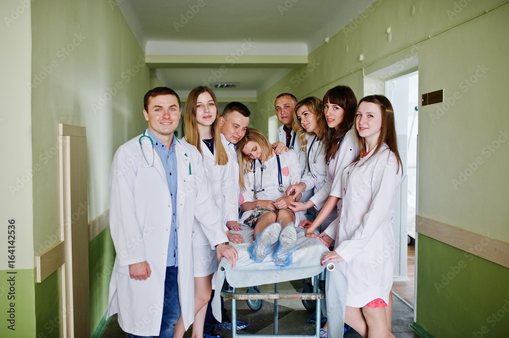 Fototapeta premium Funny doctors posing on the bed for ill patients in the hospital.