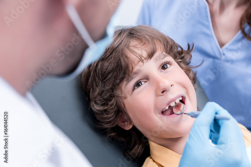 dentist examining teeth of little boy in dental clinic