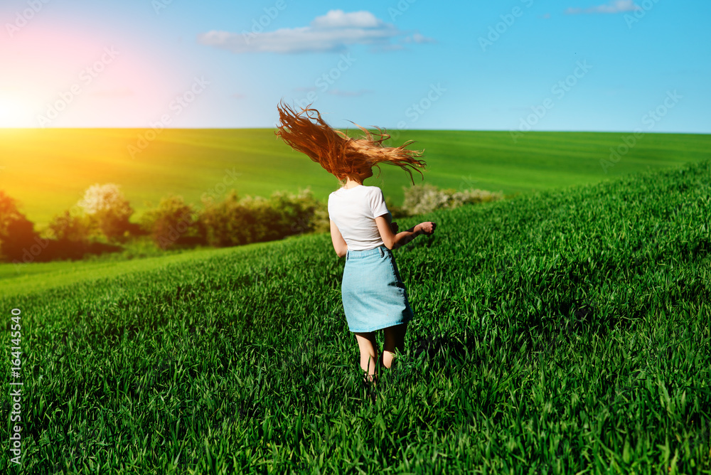 Young beautiful woman running on a green field Young beautiful woman running on a green field