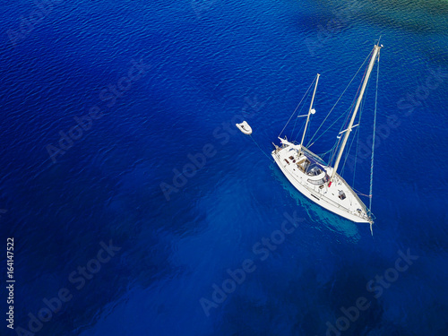 Aerial shot of beautiful blue lagoon at hot summer day. Top view of sailing boat ready for cruise. © dusanpetkovic1