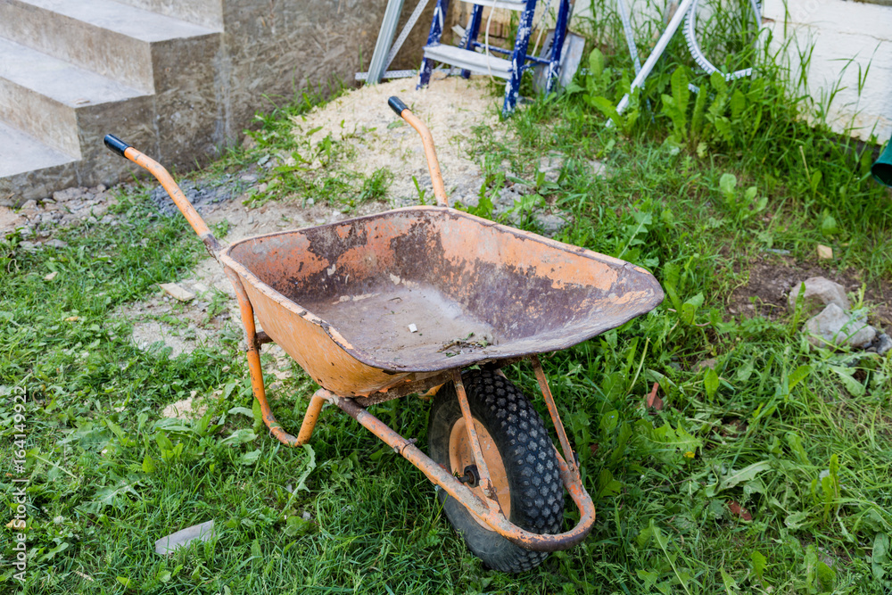 Dirty iron trolley for manual moving of building materials in the garden and in the backyard
Dirty iron trolley for manual moving of building materials in the garden and in the backyard