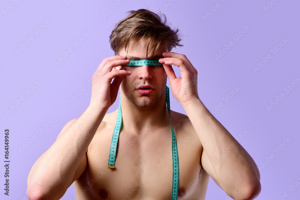 Man with serious face and tied eyes with flexible ruler Man with serious face and tied eyes with flexible ruler