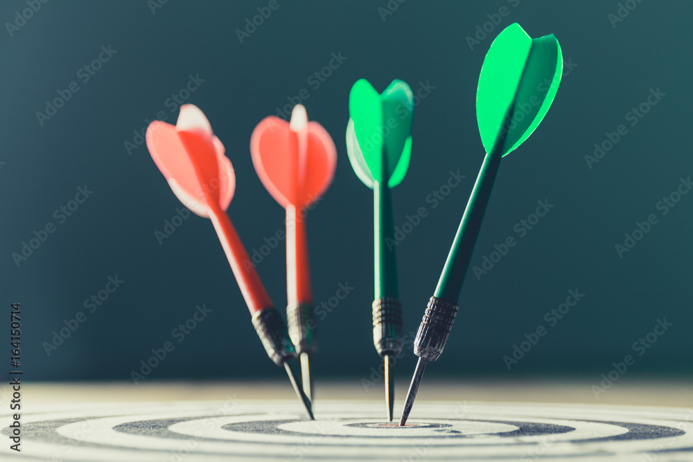 dart arrow hitting in the target center of dartboard,abstract of success